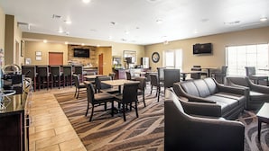 A hotel lobby with a bar area, seating, and a television. - Cobblestone Hotel & Suites - Paxton (Paxton)