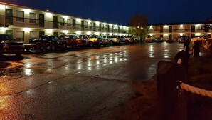 Un motel con diversi posti auto e una fila di camere dotate di balcone.