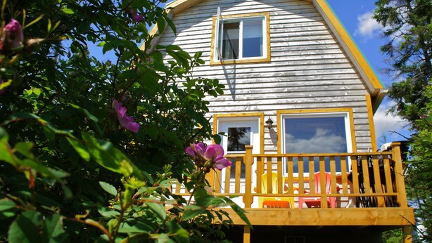 Una casa de madera con un balcón, una ventana y una puerta.