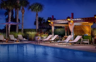 Una piscina al aire libre, camas de piscina con cargo, sombrillas