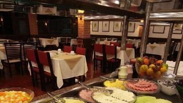 Buffet com diversas opções de comida, incluindo frutas, legumes e carnes.