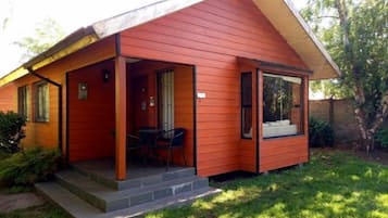 Einbungalow mit Veranda, einem kleinen Tisch und Stühlen sowie einem Fenster.