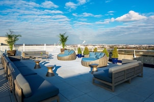 Terraza en la azotea con mobiliario exterior, sofás y sillones, además de plantas en macetas.