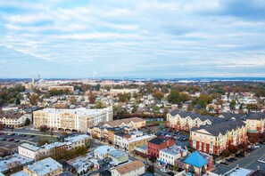 A cityscape with a mix of residential and commercial buildings, a prominent tower in the distance, and a river running through the center. - Watt Hotel Rahway, Tapestry Collection by Hilton (Rahway)