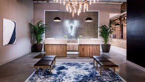A modern lobby with a central seating area, two sinks, and a neon art piece on the wall. - Watt Hotel Rahway, Tapestry Collection by Hilton (Rahway)