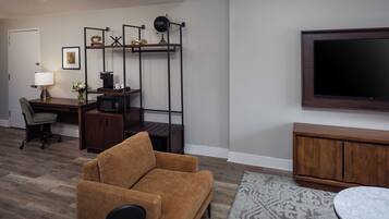 A living room with a sofa, a desk, a TV, and a cabinet.
