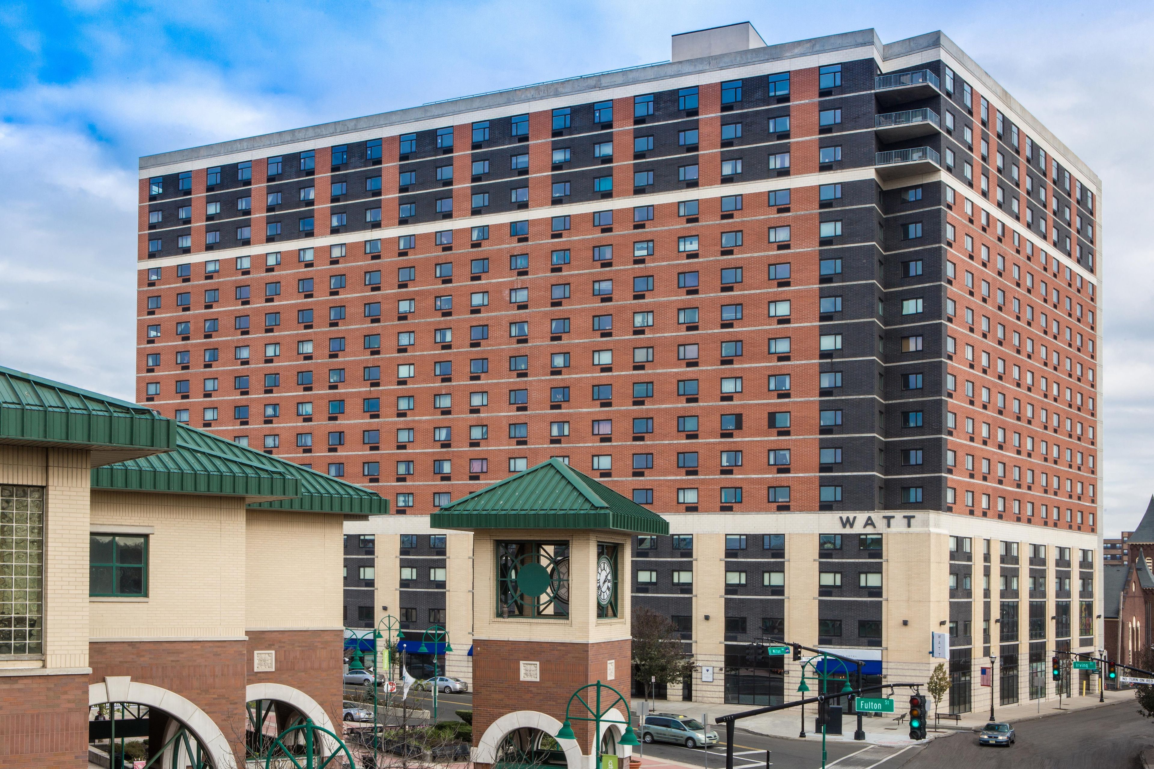 A multi-story building with a brick facade and a flat roof.