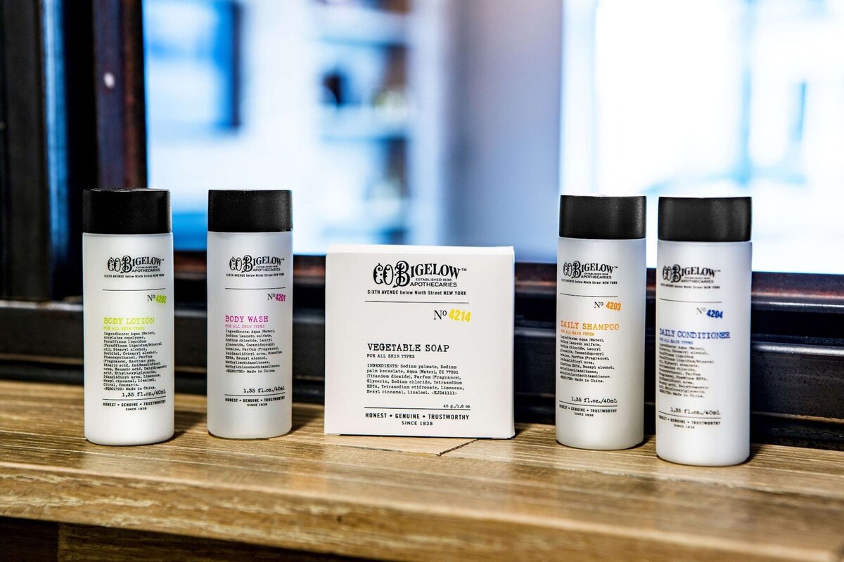 Five bottles of body care products and a sign in the center.