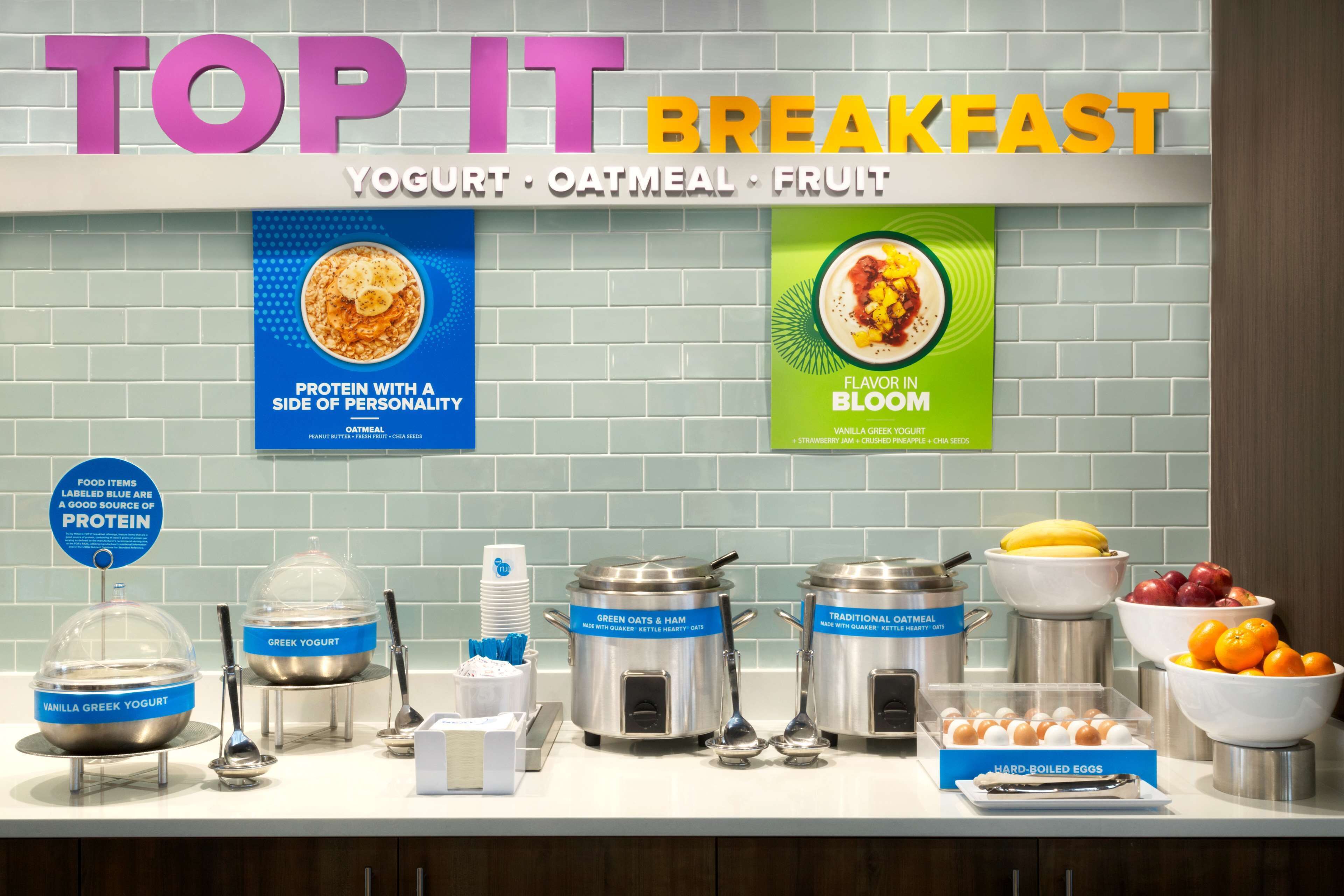 Un bufé de desayuno con alimentos identificados, incluyendo yogur, avena y fruta.