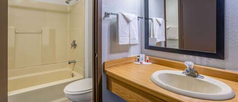 A bathroom with a bathtub, toilet, sink, and mirror.