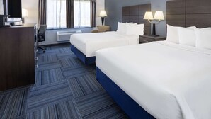A hotel room with two beds, a desk with a TV, a chair, a window with curtains, and two bedside lamps. - Baymont by Wyndham Appleton (Appleton)