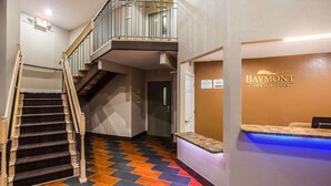 A hotel lobby with a staircase, a reception desk, and a sign for Baymont Inn & Suites. - Baymont by Wyndham Appleton (Appleton)