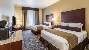 Habitación de hotel con dos camas, televisor, escritorio y ventana con cortinas.