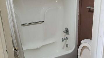 Een bad/douchecombinatie, handdoeken