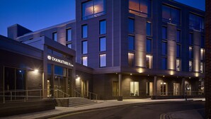 A modern hotel with a flat facade, large windows, and a well-lit entrance.