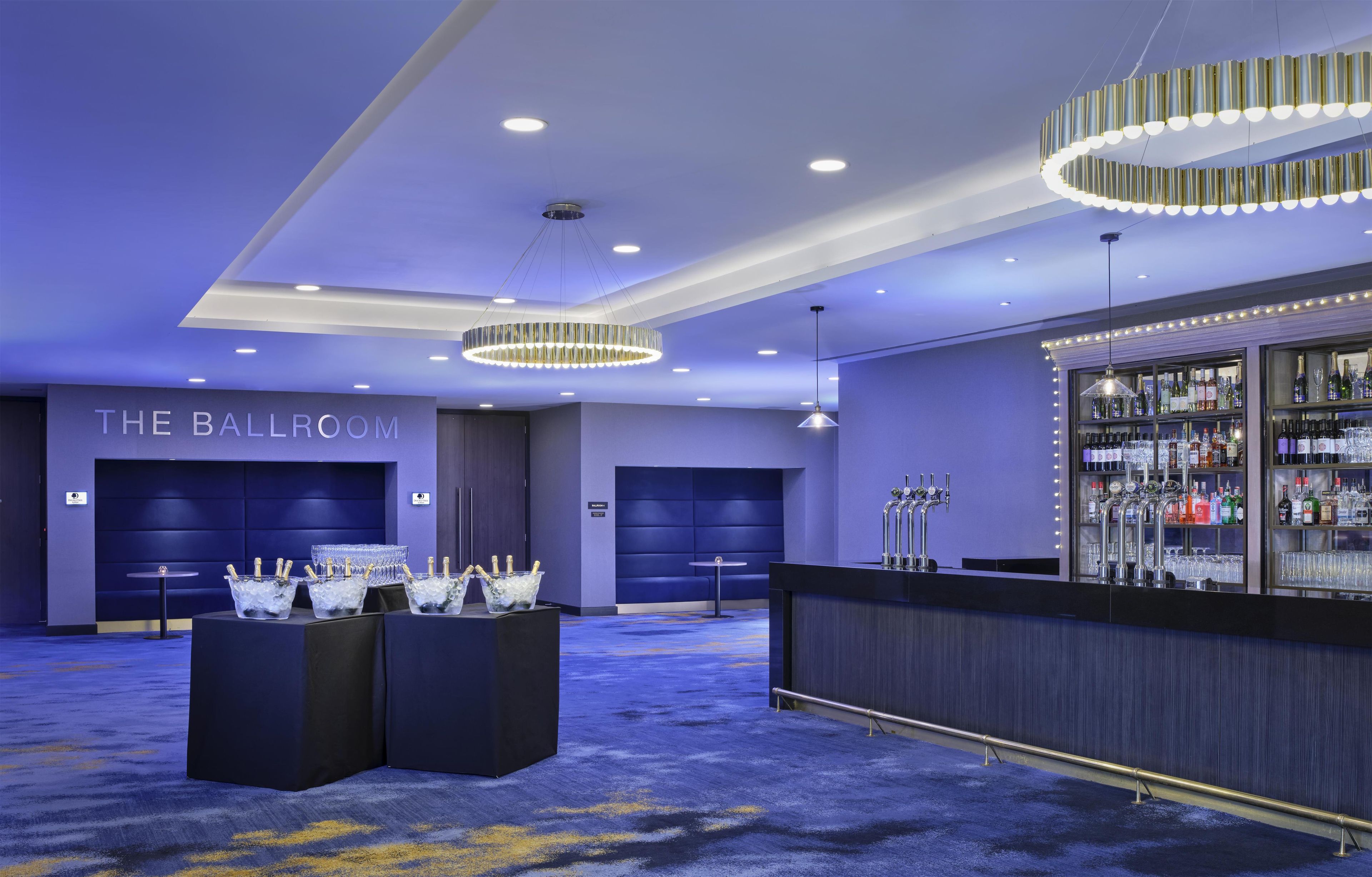 A bar area with a minibar, ice buckets with champagne, and a sign that reads 'THE BALLROOM'.