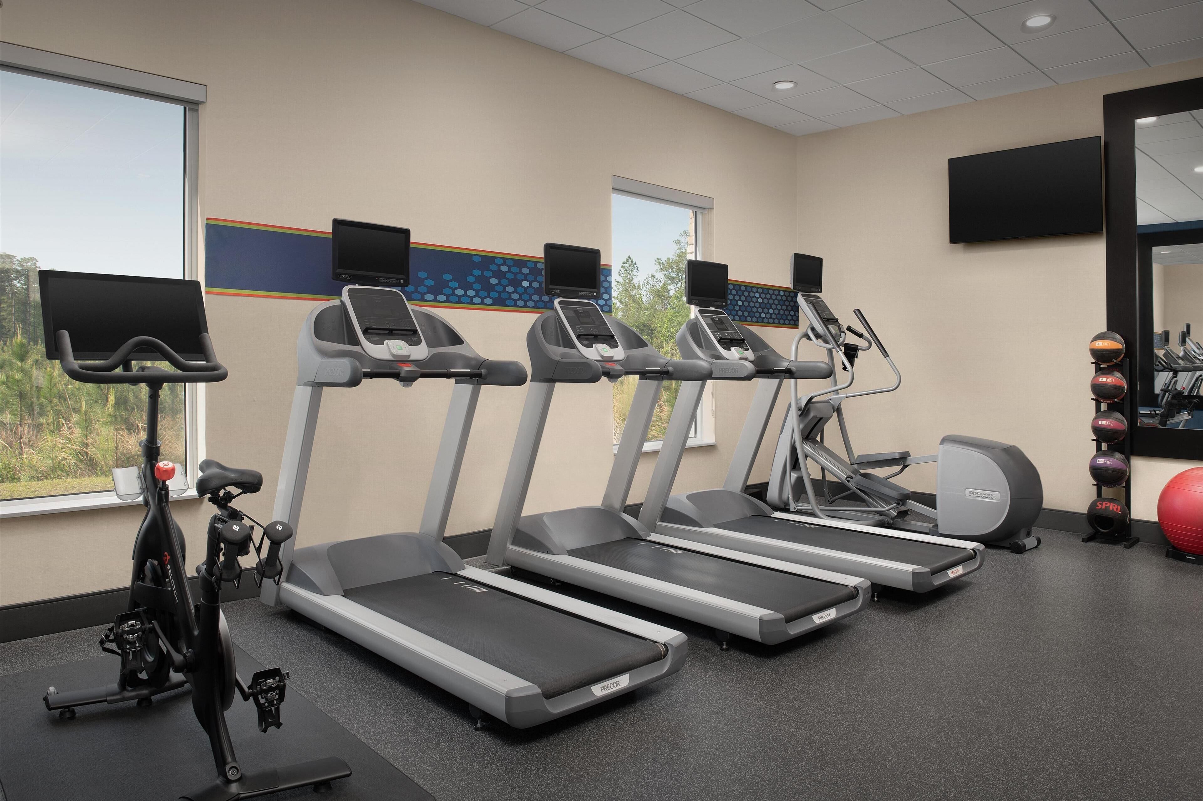 Ein Fitnessstudio mit Laufbändern, einem Ergometer und Trainingsbällen.