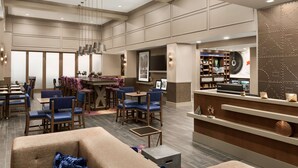 A spacious lobby with a bar area, seating arrangements, and a reception desk. - Hampton Inn & Suites Seattle/Renton (Renton)