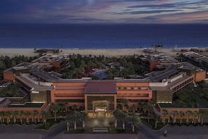 A hotel with a central entrance, multiple floors, and a beach view. - Hilton Cabo Verde Sal Resort (Sal)