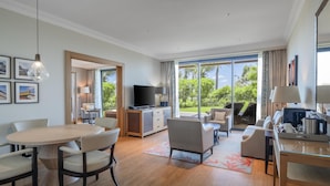 A modern hotel room with a dining area, a sofa, a TV, and a large sliding glass door to the outdoors. - Hilton Cabo Verde Sal Resort (Sal)