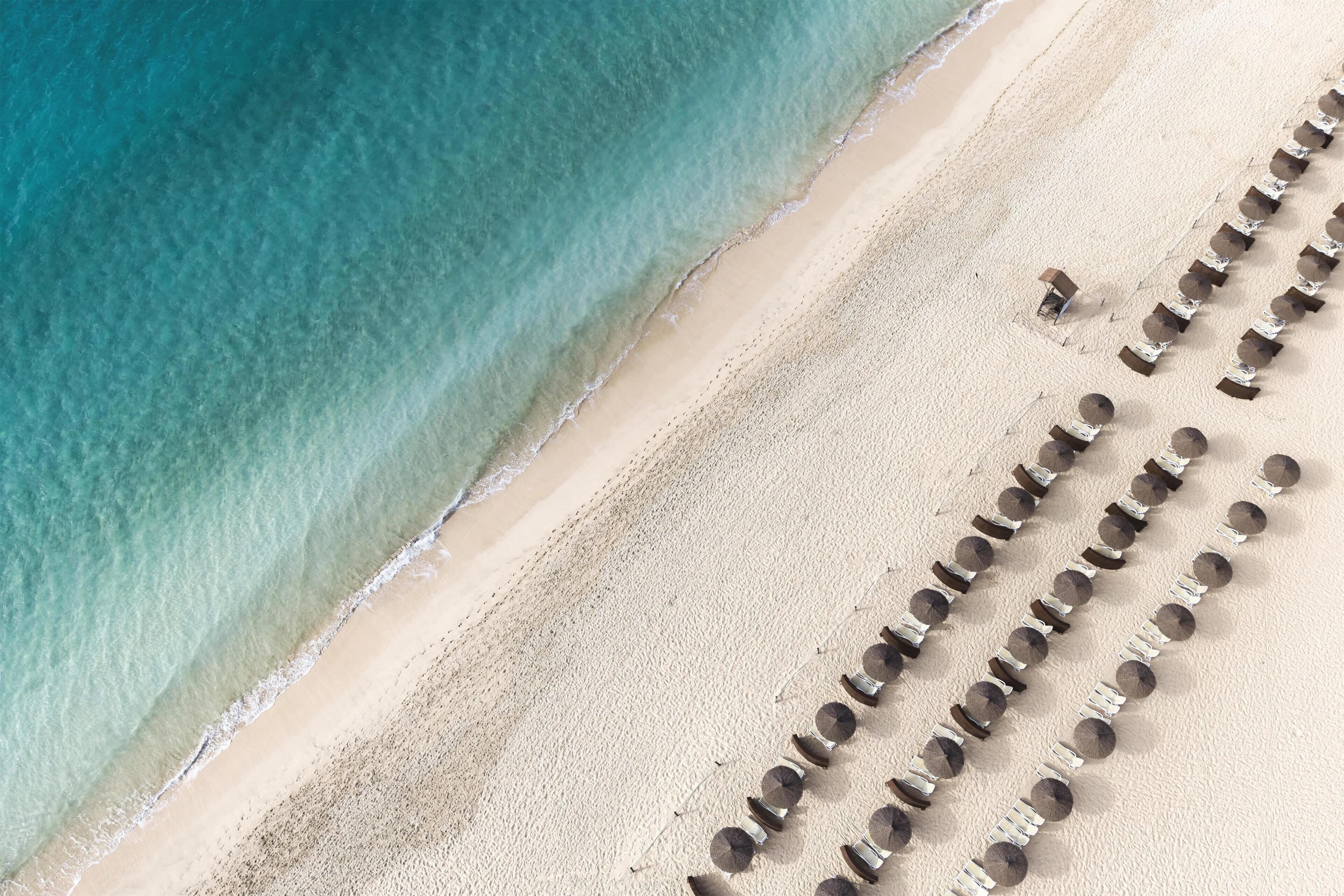 On the beach, white sand, sun loungers, beach umbrellas