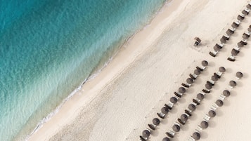 On the beach, white sand, sun loungers, beach umbrellas