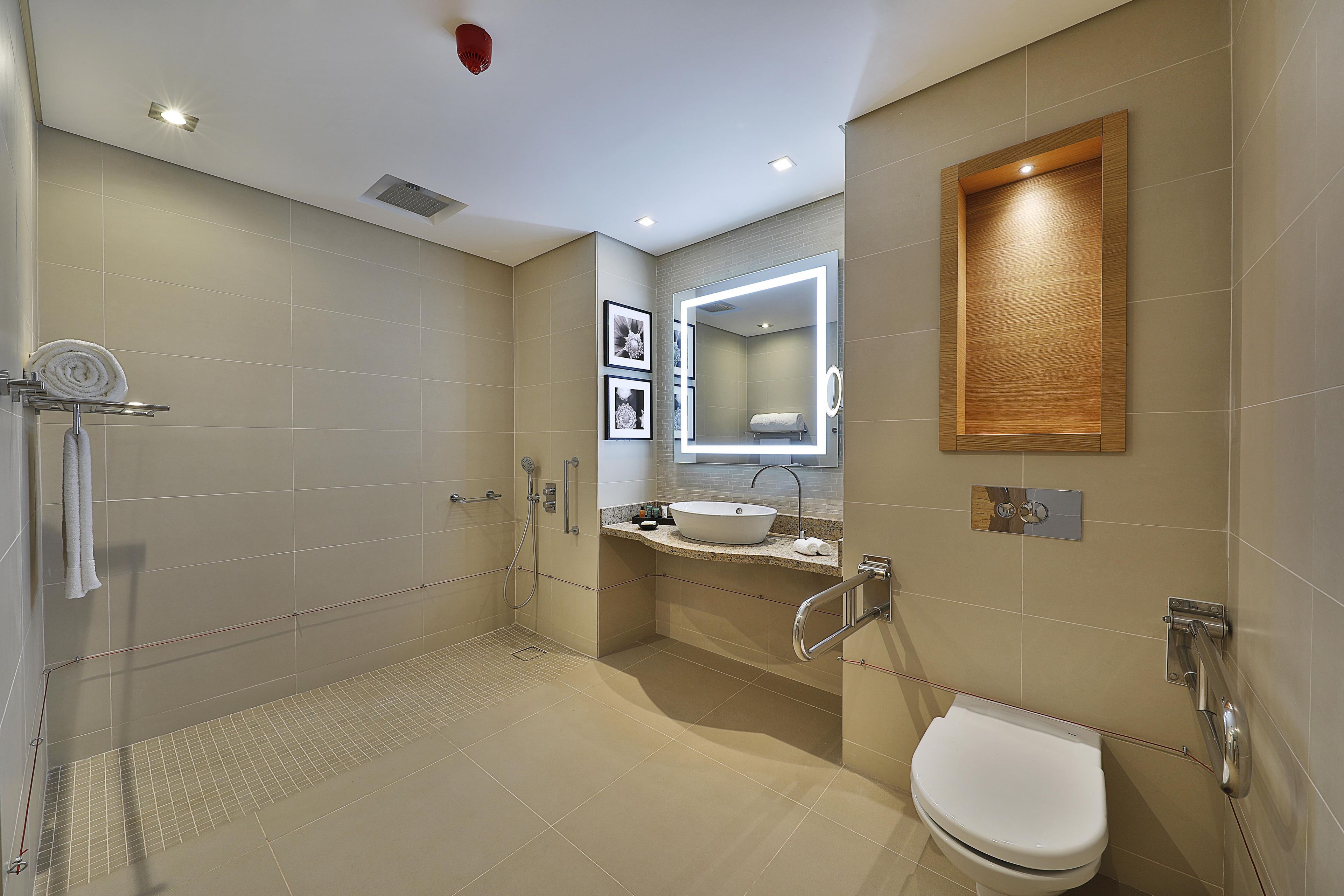 Un baño moderno con cabina de ducha, inodoro y tocador con lavamanos.