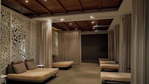A room with multiple beds arranged in a row, a decorative wall, and a ceiling with wooden beams. - Hilton Cabo Verde Sal Resort (Sal)