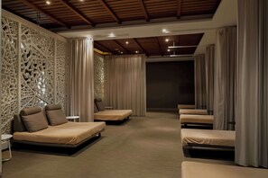 A room with multiple beds arranged in a row, a decorative wall, and a ceiling with wooden beams. - Hilton Cabo Verde Sal Resort (Sal)