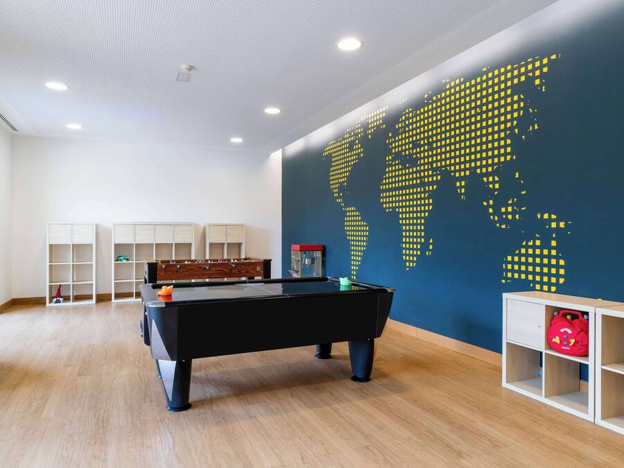 Ein Zimmer mit Billardtisch, Regalen und einer Weltkarte an der Wand.
