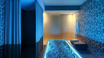 A modern spa area with a heated floor, a bench, and a towel rack.