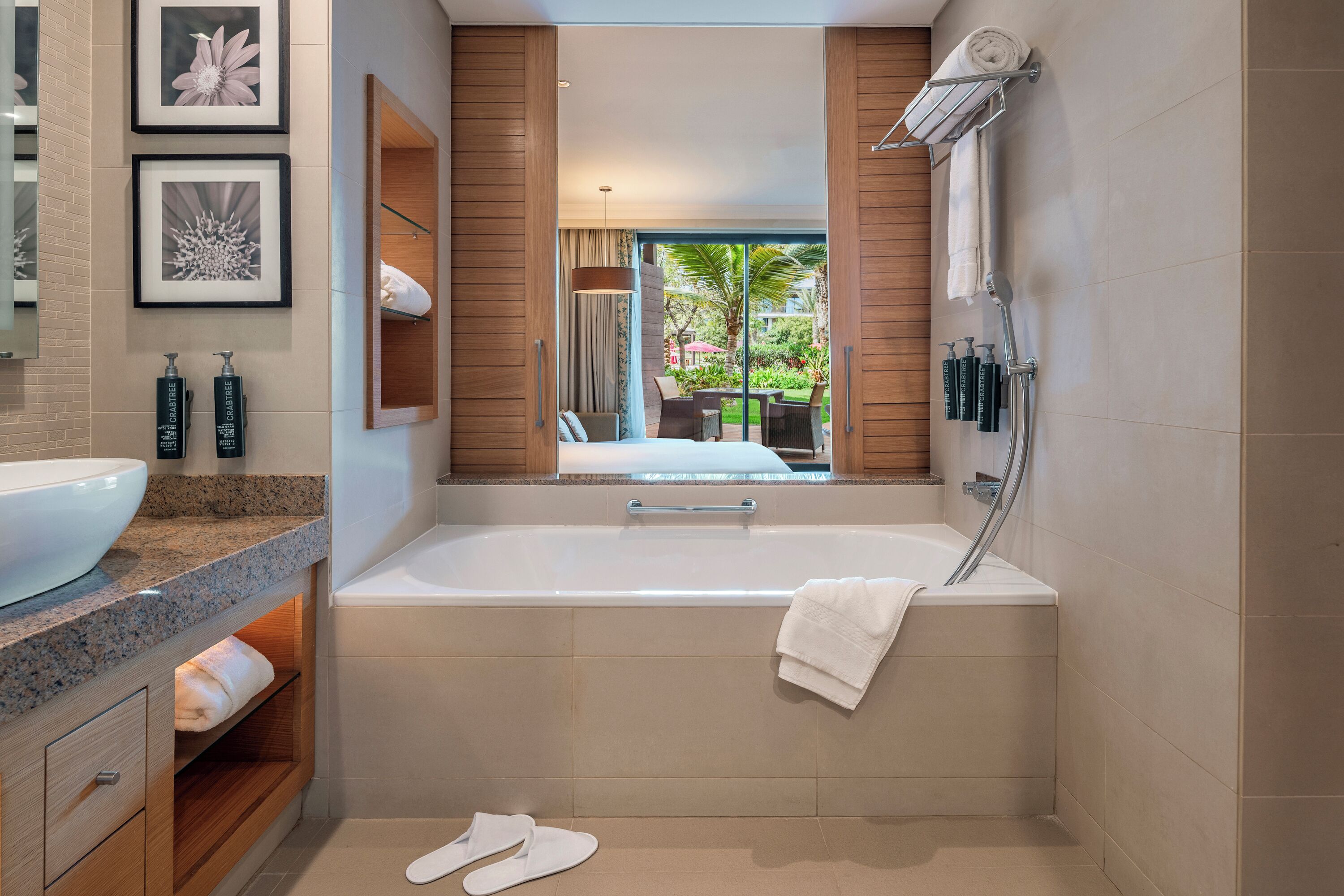A modern bathroom with a large bathtub, a vanity with a bowl sink, and a mirror.