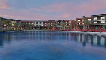 Un hotel con una piscina grande, varios pisos y un diseño arquitectónico moderno.