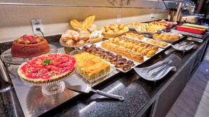Un buffet proposant une variété de desserts, notamment des gâteaux, des pâtisseries et une tarte au chocolat.