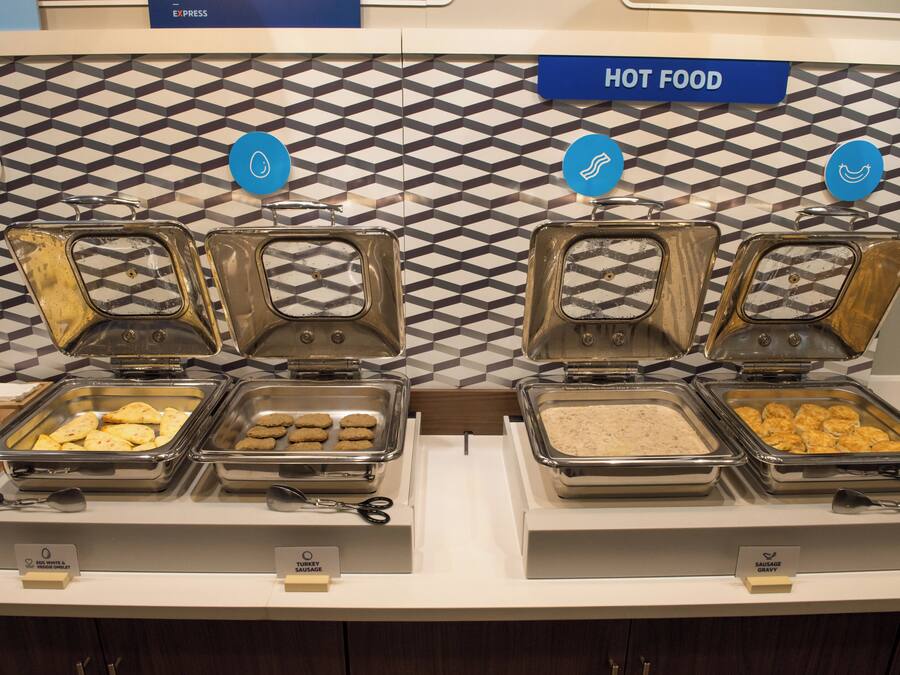 A buffet setup with labeled food sections including egg white & veggie omelet, turkey sausage, and sausage gravy.