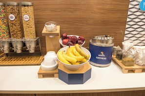 Un bufé de desayuno con diversas opciones de comida, incluyendo cereales, frutas y avena.
