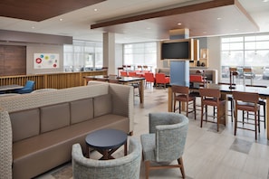 A modern dining area with a mix of seating options including a sofa, chairs, and tables. - Holiday Inn Express & Suites Portland Airport - Cascade Stn by IHG (Portland)