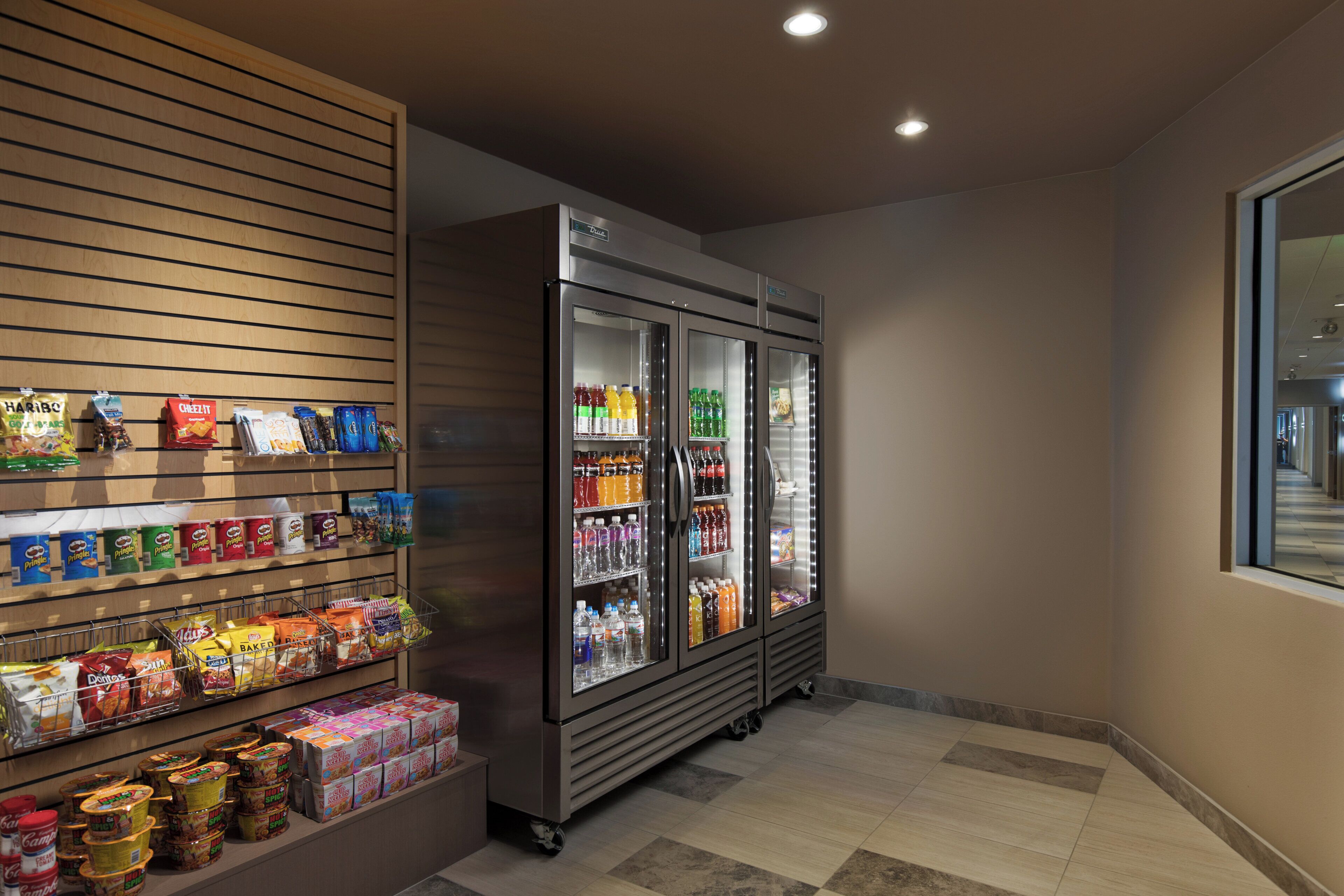 A snack and beverage display area with refrigerated sections and shelves stocked with various products.