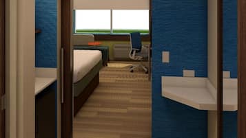 A hotel room with a bed, a desk, a chair, and a window.