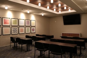 A conference room with tables and chairs, a flat-screen TV, and framed artwork on the wall. - Holiday Inn Express & Suites Portland Airport - Cascade Stn by IHG (Portland)