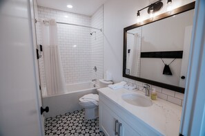 A modern bathroom with a bathtub, toilet, and sink.