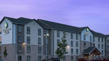 A multi-story hotel with a sign reading "Woodspring Suites."