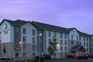 Un hotel de varios pisos con un cartel que dice "Woodspring Suites".