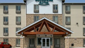 A multi-story hotel with a stone facade and a prominent 'Woodspring Suites' sign. - WoodSpring Suites Cherry Hill (Cherry Hill)
