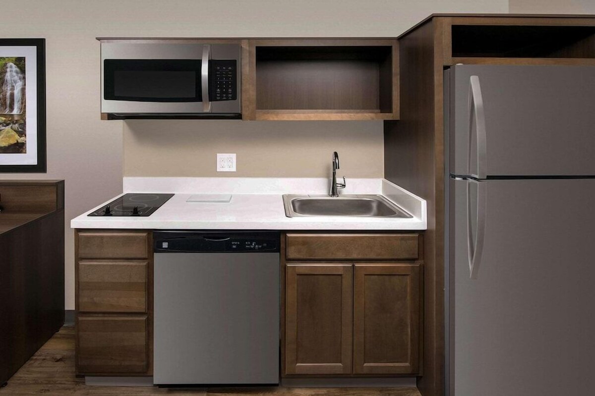 A kitchen with a dishwasher, microwave, sink, and refrigerator.