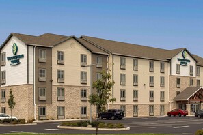 A hotel with a modern design, featuring a stone facade and multiple windows. - WoodSpring Suites Cherry Hill (Cherry Hill)