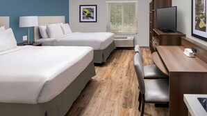 A hotel room with two beds, a desk with a chair, a TV, and a window with blinds. - WoodSpring Suites Cherry Hill (Cherry Hill)