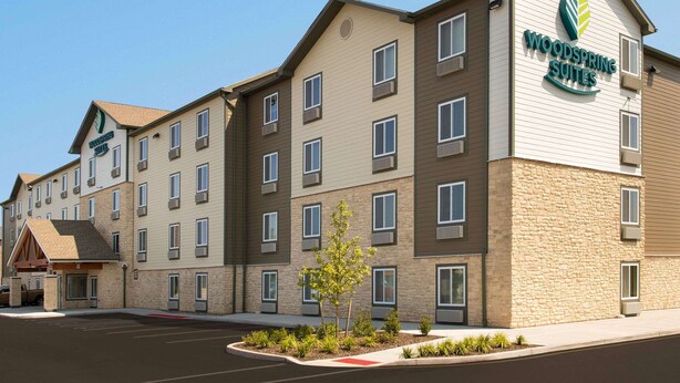 A multi-story hotel with a sign for "Woodspring Suites." - WoodSpring Suites South Plainfield (South Plainfield)