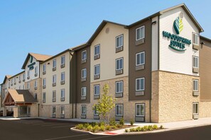 Ein mehrstöckiges Hotel mit einem Schild, auf dem "Woodspring Suites" steht.