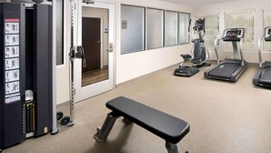 A gym with exercise equipment, a bench, and treadmills. - WoodSpring Suites South Plainfield (South Plainfield)
